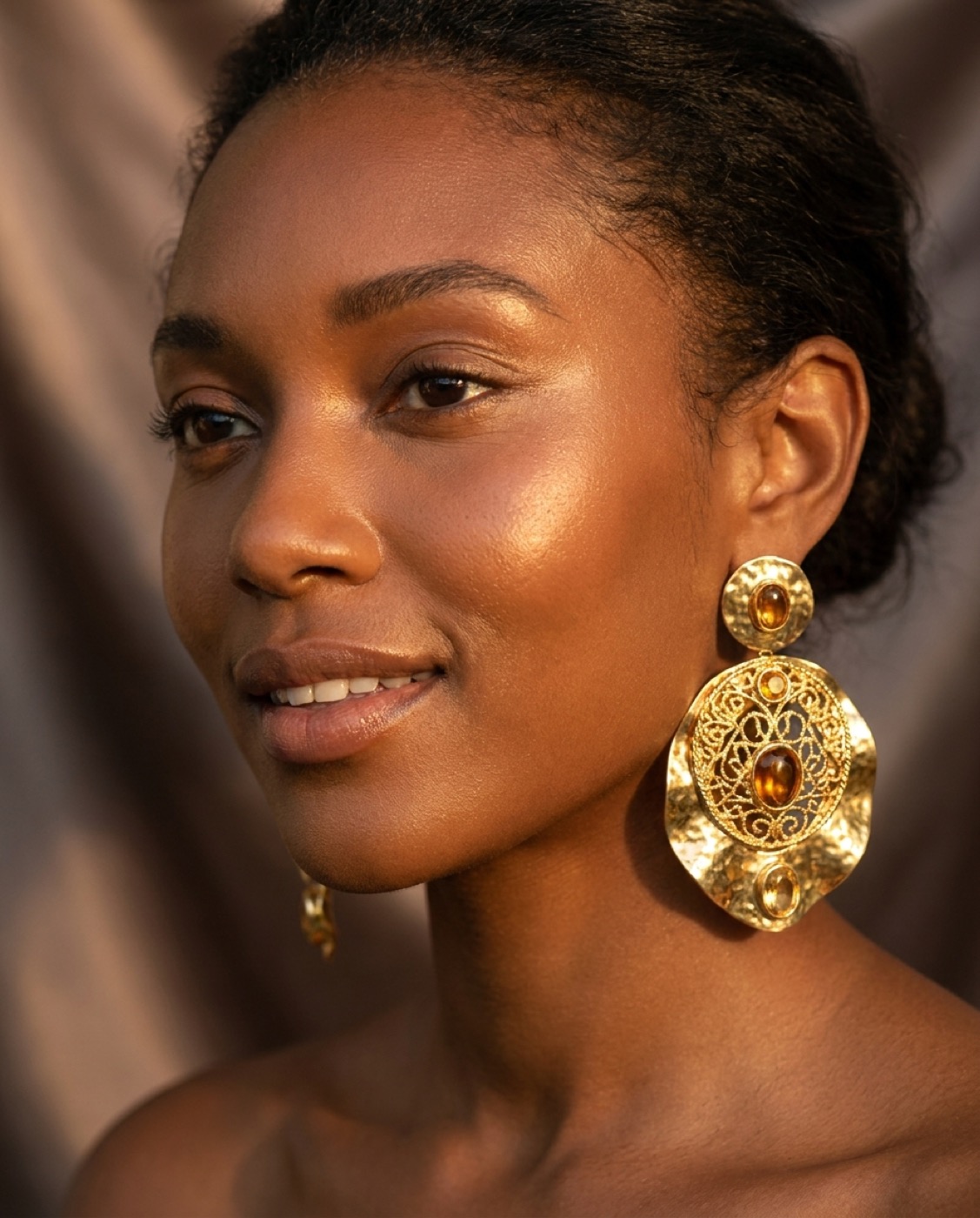 A client wearing a handcrafted gold statement earring from Whitfield & Sons